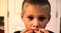Young Boy Eating A Very Sour Candy Making Funny Facial Expressions