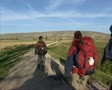 Pilgrims Walking In Spanish Rural Landscape At Castrojeriz