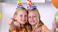 Twin Sisters With Thumbs Up At Birthday Party