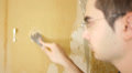 Man Removes Wallpaper With Razor Scraper
