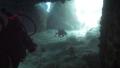Diver Swimming Through Cave
