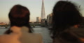 Two Friends Chatting In The Evening With London Skyline In The Background.