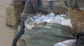 Women Sort Through A Large Bag Of Empty White Plastic Water Bottles