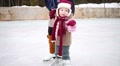 Girl Teaches Younger Sister Of Skate At Rink In Winter Day