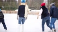 Mother, Father, Daughter And Son Skate On Ice Rink At Winter