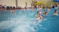 Adults And Children Play In Indoor Pool In Holiday House