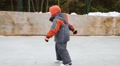 Little Handsome Boy Learns To Skate At Ice Rink In Winter Day
