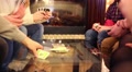 Hands And Knees Of Eight People Playing Table Game With Cards In Room