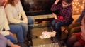 Seven People Play Card Game And Have Fun In Room With Fireplace
