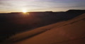 Sun Setting Behind Red Sand Dune In Slow Motion