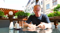 4k. Adult Man Makes Choice Of Dishes In Street Café. Slider Shot