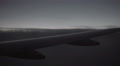 Closeup Of Airplane Wing Flying In Dark Gloomy Sky - Gray Clouds In Flight