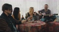 Friends Resting In Country House At Table With Drinks. Man Playing Guitar Sing
