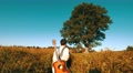 Walking Guitarist At The Field With Lonely Tree