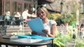 Businesswoman Working On Papers In The Outdoor Cafe And Smiling To The Camera