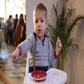 Cute Little Child Boy Funny Sit In Restaurant And Looks Like Make An Order
