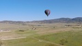 Rainbow Hot Air Balloon Over Green Fields - Drone