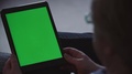 Man Holds Blank Green Screen Tablet In Portrait Mode At Home