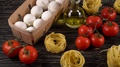 Pasta, Eggs, Oil, Tomatos And Garlic On Wooden Background