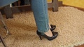 A Woman Takes Off Her Shoes In Heels. Legs Of A Girl In Jeans And Shoes.