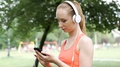 Sporty Girl Listening Music In The Park And Browsing Internet On Smartphone, Ste
