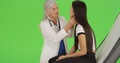 An Older Doctor Gives A Check-Up To A Young Girl On Green Screen