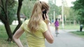 Girl Going Round On The Pathway And Chatting On Cellphone, Steadycam Shot