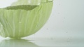 A Green Cabbage Leaf Rolling On Water Surface. Slow Motion.