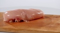 2 Pieces Of Raw Chicken Fillet Falls On A Wooden Board, Than Taken From A Wooden