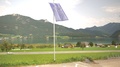 European Union Waving Flag With A Highway, Lake And Mountains View.