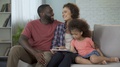 Parents Showing Daughter Her First Photos On Tablet, Cozy Family Atmosphere