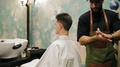 Bearded Hairdresser Is Applying Gel On The Hair Of A Stylish Male Customer In A