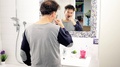 Man Washing Teeth In Bathroom In Pajamas In Front Of Mirror Wide Shot