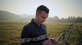 Handsome Man Is Using Smartphone Outdoors At Sunset With Lense Flare In Nature