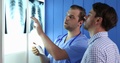 Medical Doctor Man Checking Pulmonary X-Ray Using Digital Tablet Talking Patient