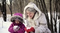 Mom And Daughter, A Little Child, Blowing On The Snow. Slow Motion.