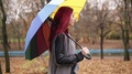 Side View: Young Woman With Red Hair Walking In Autumn Park And Drinking Coffee
