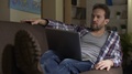 Adult Man Sitting On Sofa With Computer On Lap Thinking, Future Plans, Choice