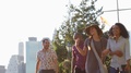 Group Of Friends Walking With Manhattan Skyline In Background