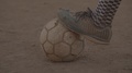 Old Boot Rests On Worn Football In Africa - No Grade Prores422