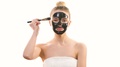 The Happy Woman Applying A Skin Care Face Mask On The White Background