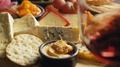 Pull Focus Of Swirling Wine From Cheese And Cracker Platter