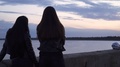 Two Girls Bikers In Leather Jackets Enjoy Beautiful Evening View At The Sea