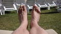 Point Of View Of A Man Who Lies On A Deckchair And Sunbathing. The Legs Of A