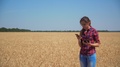 Near Field With Grain Agronomist With Tablet In Her Hands Talking On Mobile