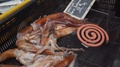 Squids In A Black Plastic Tray For Sale And An Insect Repellent Next To Them