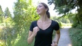 A Pretty Woman Jogging In A Park, Smiling And Enjoying The Scenery As She