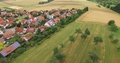 Aerial Over Fields And Town In Germany- Pan Left 4k