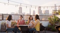 Female Friends Making A Toast To Celebrate On Rooftop Terrace With City Skyline