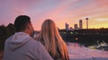 A Young Couple Stands On A Bridge Between Canada And America And Admire The City